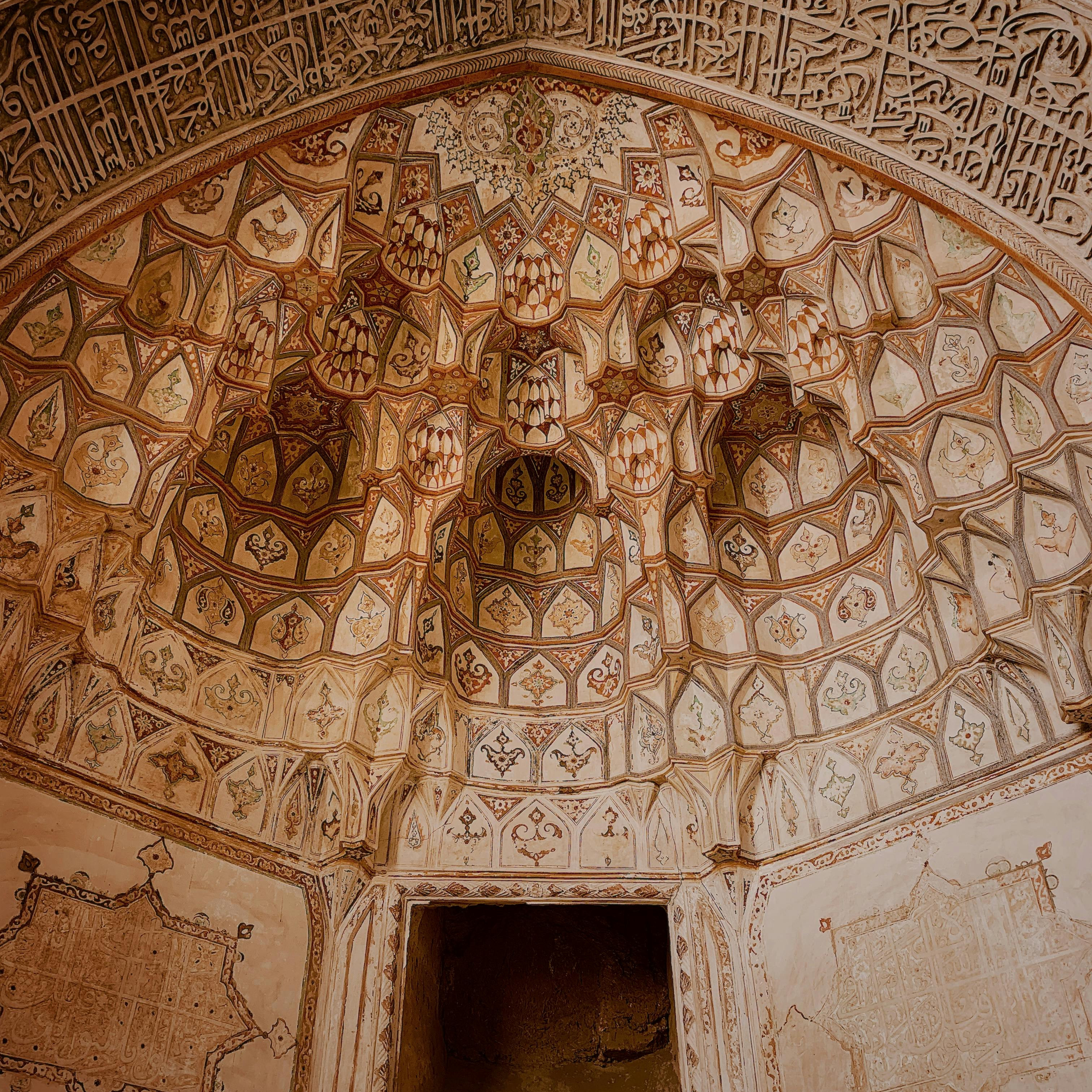 A photo of an intricately decorated ancient wall with intricate patterns and calligraphy